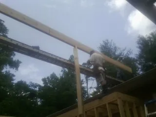 Carpenter setting a ridge beam over a new addition frame — Ice Dam Removal by Roofing Brothers in Tarzana