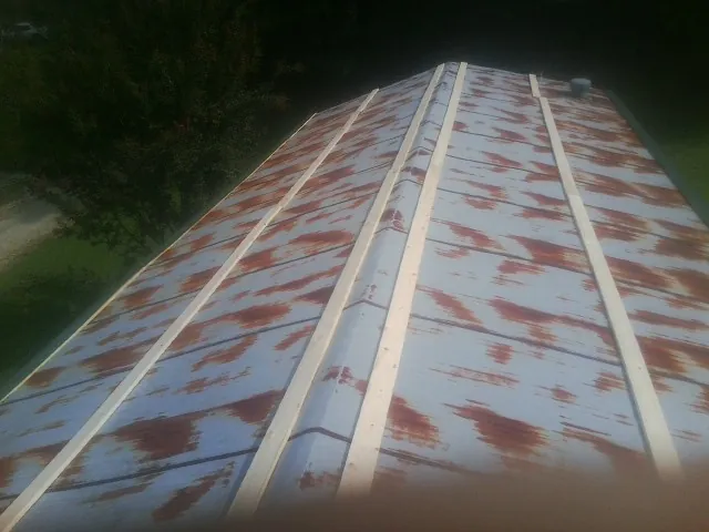 Rusted metal roof panels with new wood purlins before replacement — Storm Damage Roof Repair in Tarzana by Roofing Brothers