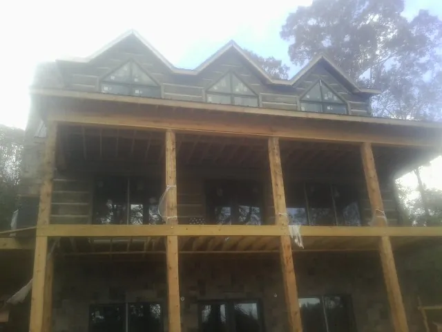 Dormers and porch framing on a large log home under construction — Roof Coating work by our crew in Tarzana